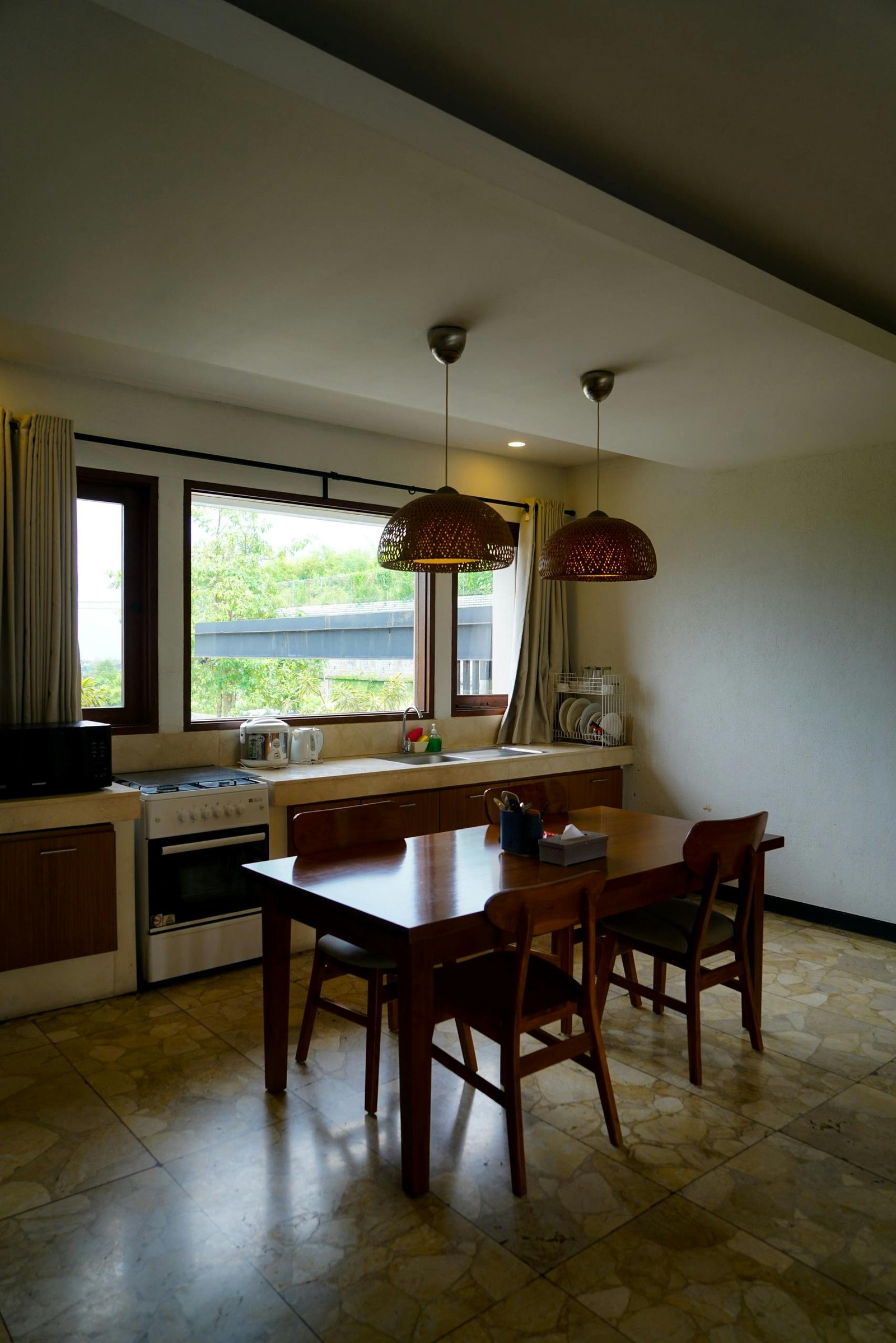A wooden kitchen table in an immigrant family home, the central spot where bills are paid, money is counted, and family financial decisions get made